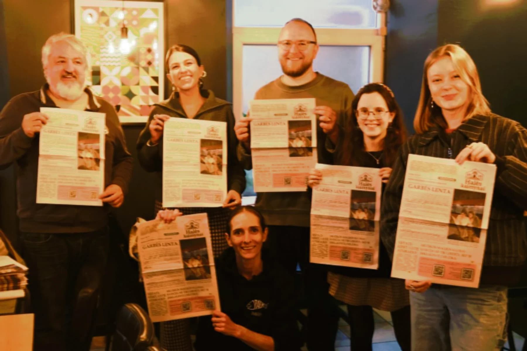 Halės kaimynai editorial team gathered around printed newspapers in Vilnius
